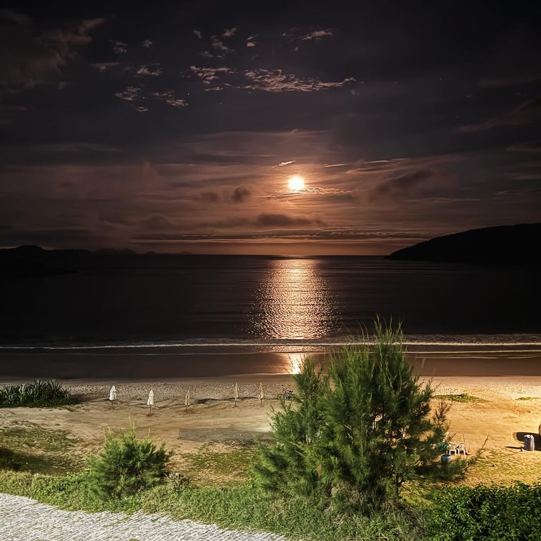 Lua cheia sobre o mar e a praia à noite